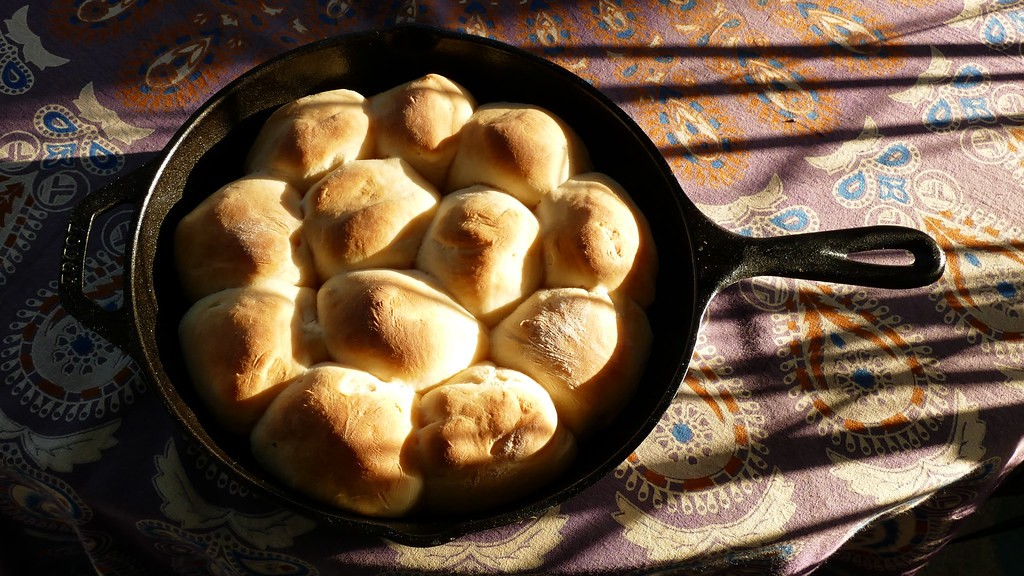 Golden pull-apart dinner rolls baked in a cast iron skillet