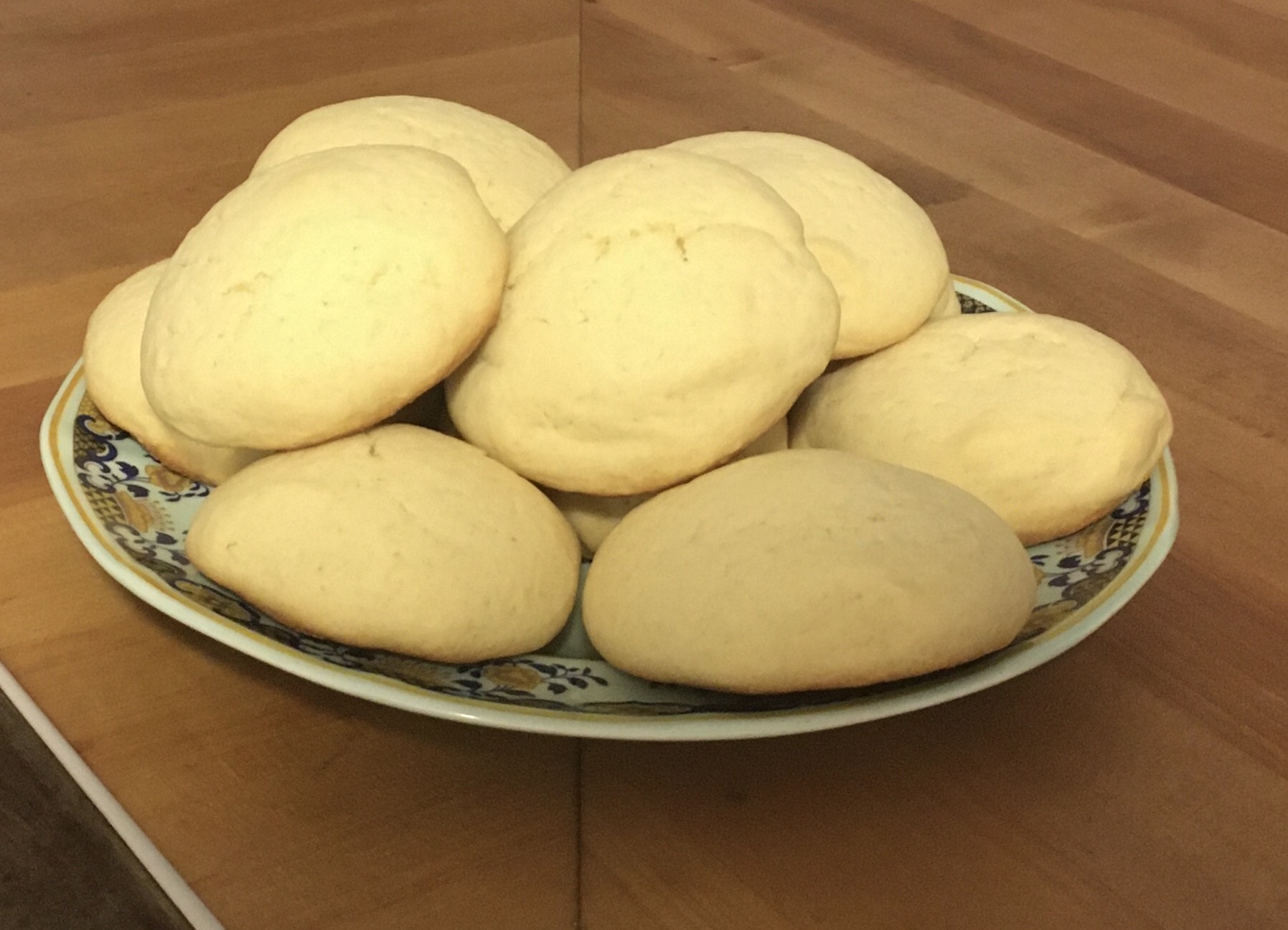 Plate of pale soft round cookies on a wooden table