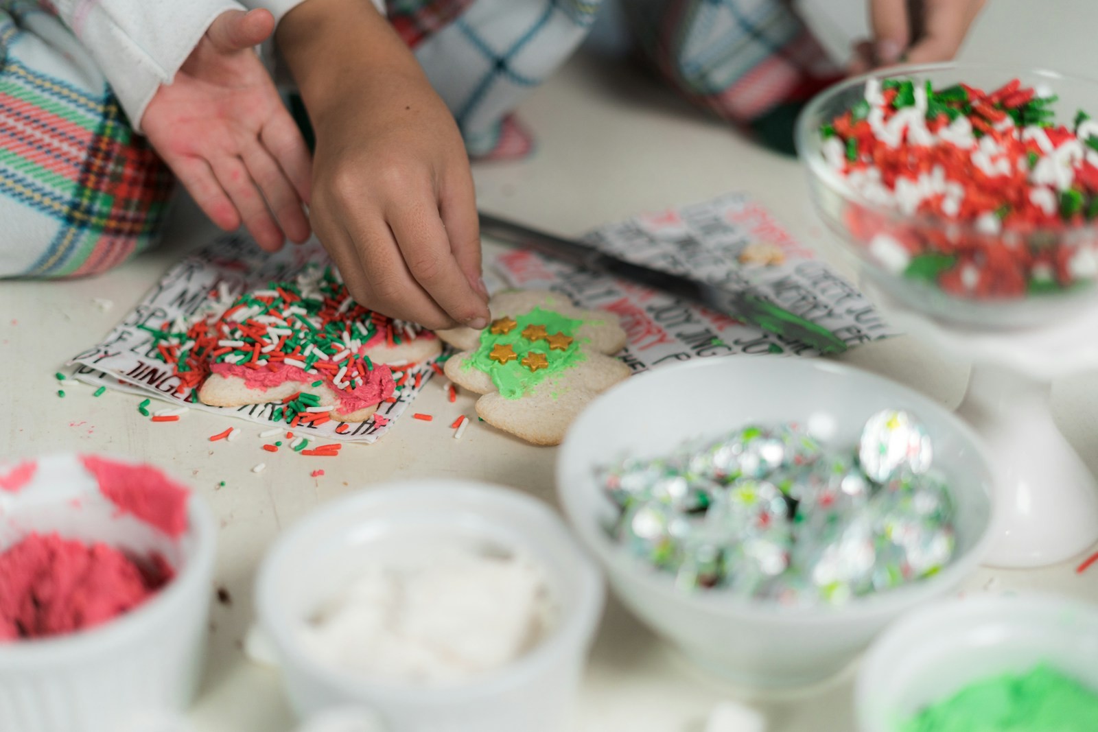 Children decorating Christmas cookies with icing and sprinkles