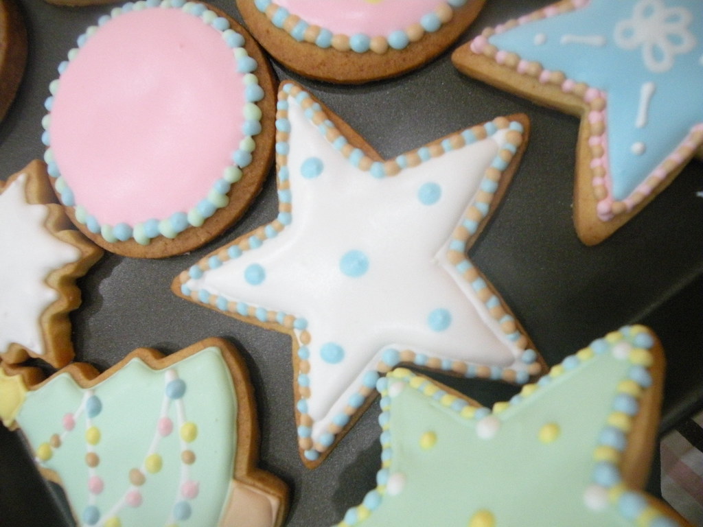 Star, round and tree cookies flooded with smooth pastel icing and piped dot borders