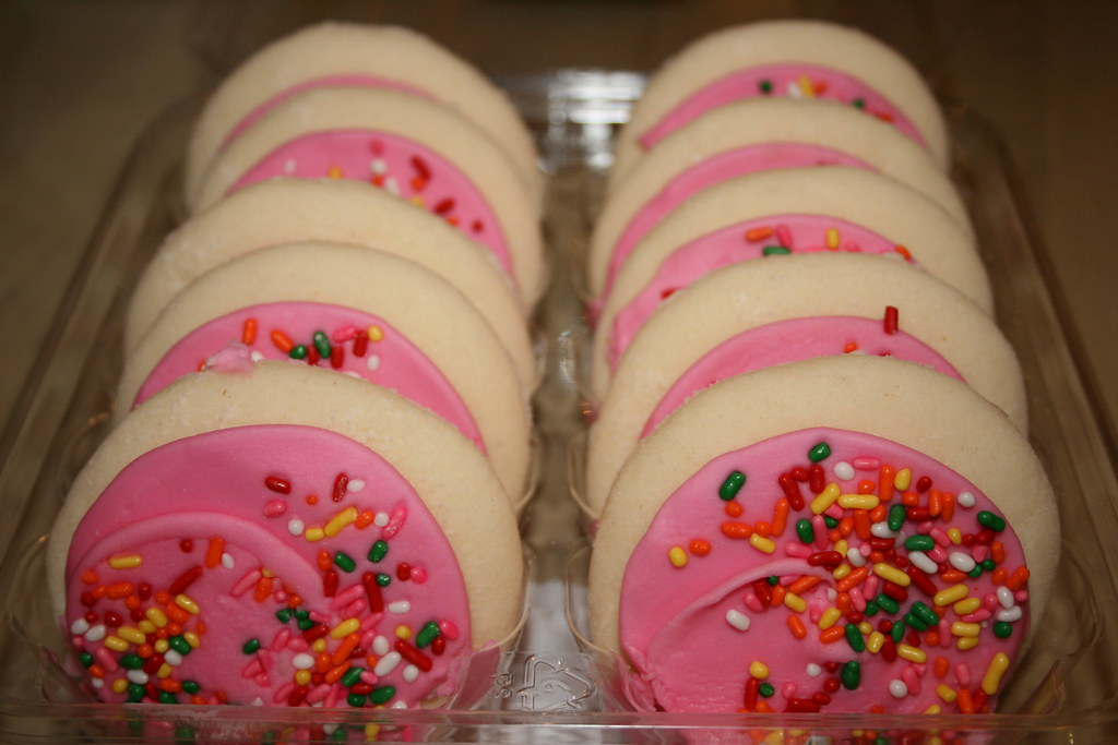 Thick soft pink frosted rounds topped with rainbow sprinkles in rows
