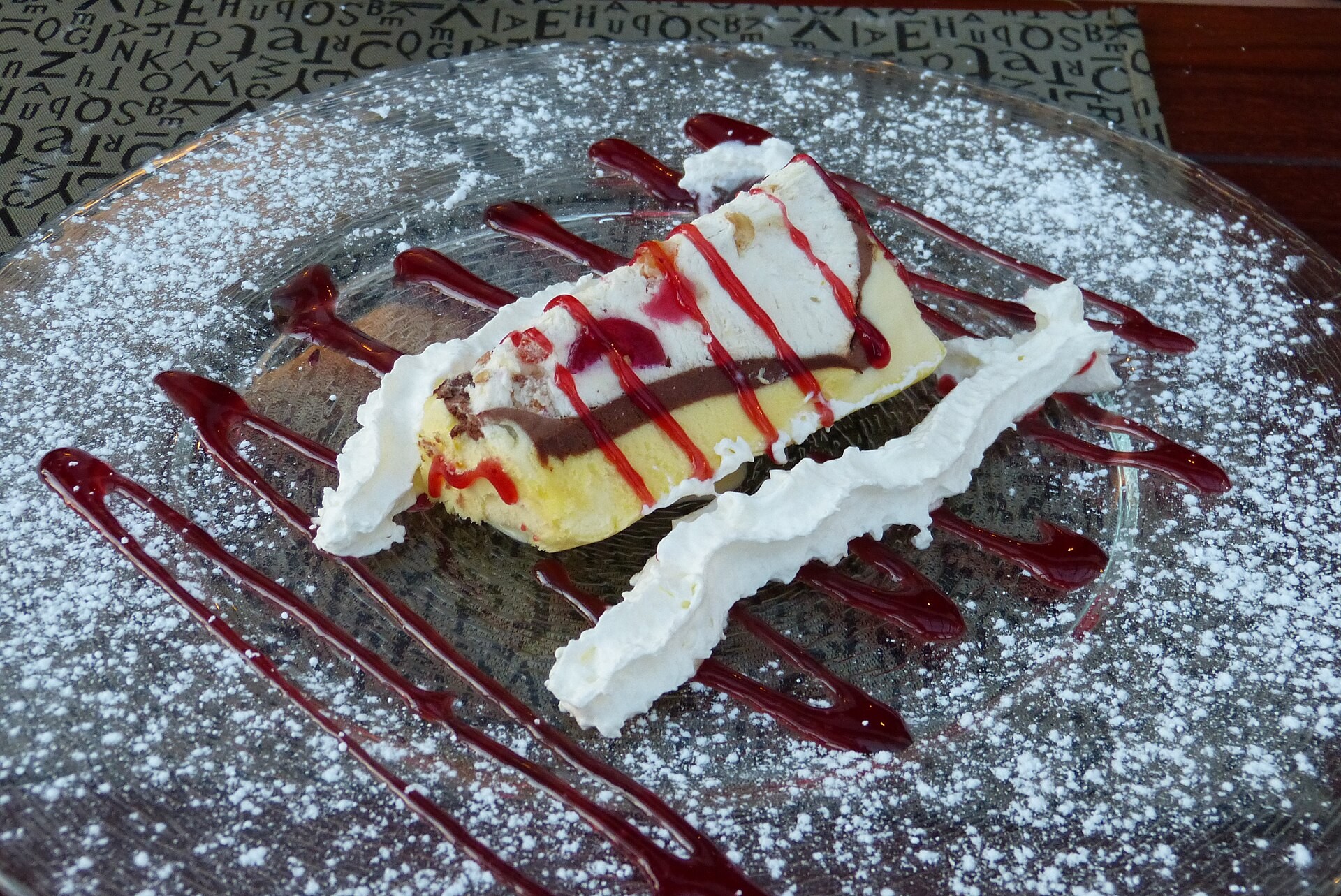 Christmas ice cream bombe slice with raspberry sauce and powdered sugar